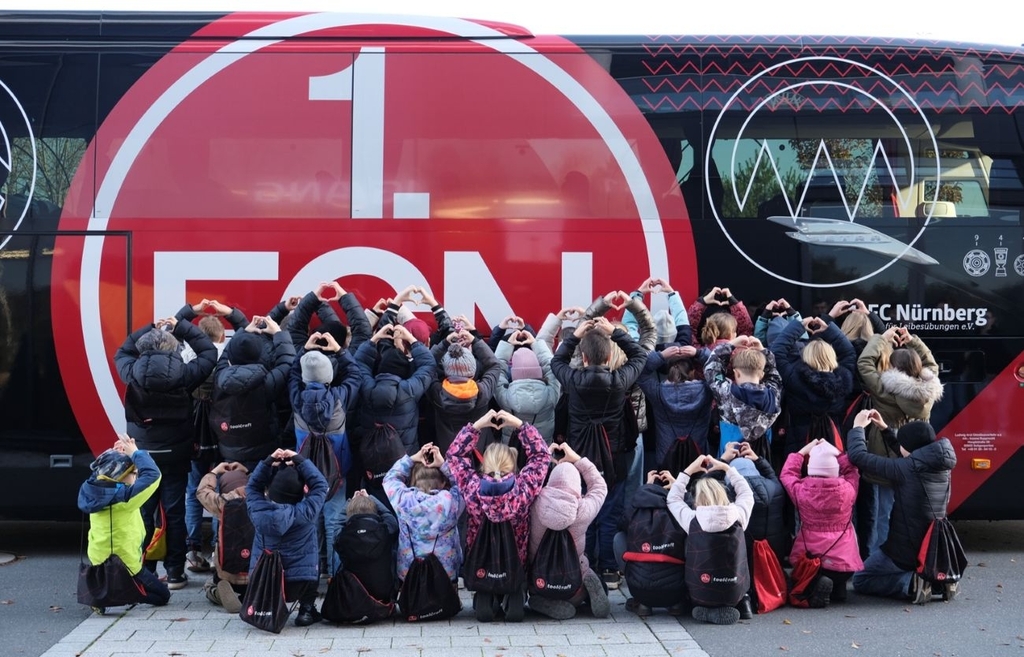 Children of toolcraft employees in front of the FCN fan bus