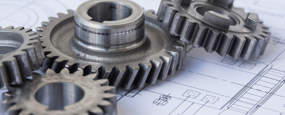 Polished steel gears interlocked and resting atop an engineering blueprint, highlighting gear teeth and shafts against detailed technical schematics and dimension lines on a white drafting sheet.