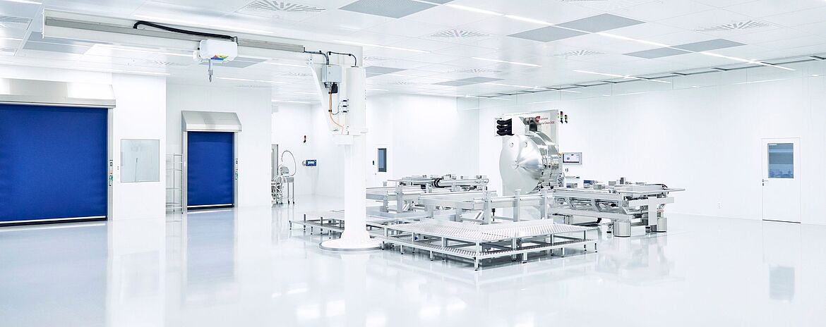 Heller Reinraum mit mehreren Anlagen zur technischen Feinstreinigung von Bauteilen, einschließlich Reinigungsanlagen, Fördertechnik und automatisierter Handhabungssysteme.