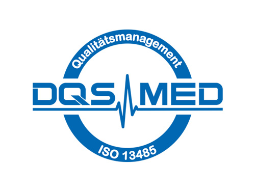 Ein kreisförmiges blaues Logo zeigt die Aufschrift „DQS MED“ mit einem Herzschlagstrich durch die Buchstaben, umgeben von einem Ring mit der Aufschrift „Qualitätsmanagement“ (oben) und „ISO 13485“ (unten) auf weißem Hintergrund.